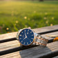 Watch with blue dial and two-tone rose gold and silver bracelet on white background